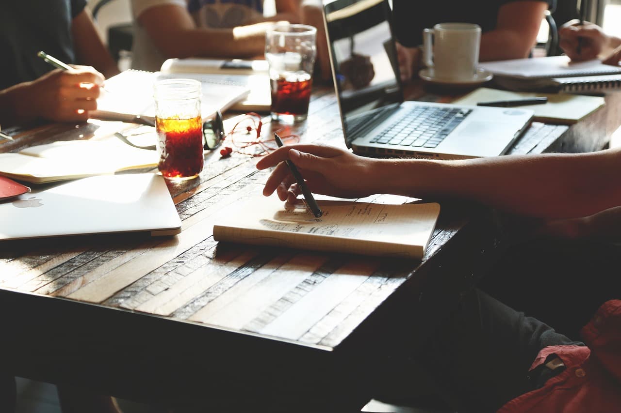 A small business owner sitting at a desk with a laptop, configuring software settings in a bright modern workspace
